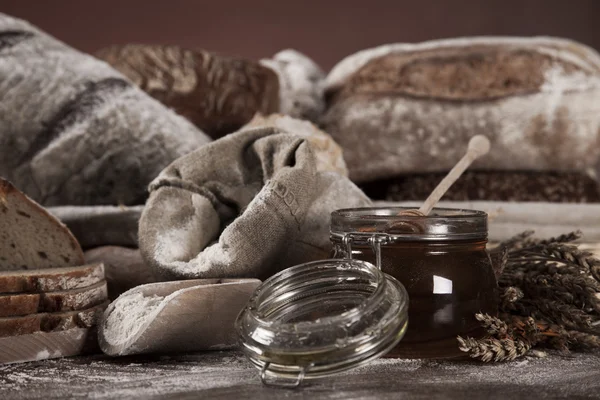 Свіжий запечений хліб і баночка меду — стокове фото