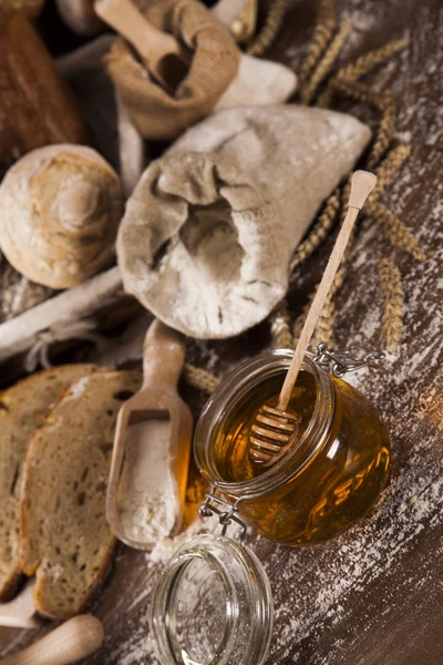 Freshly baked bread and jar of honey — Stock Photo, Image