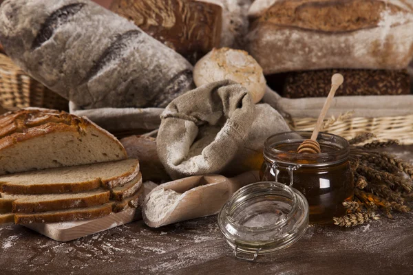 Freshly baked bread and jar of honey — Stock Photo, Image