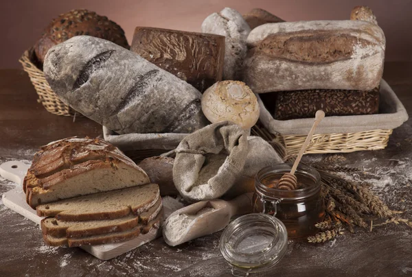 Nybakat bröd och burk honung — Stockfoto