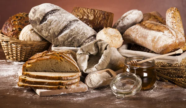 Freshly baked bread and jar of honey — Stock Photo, Image