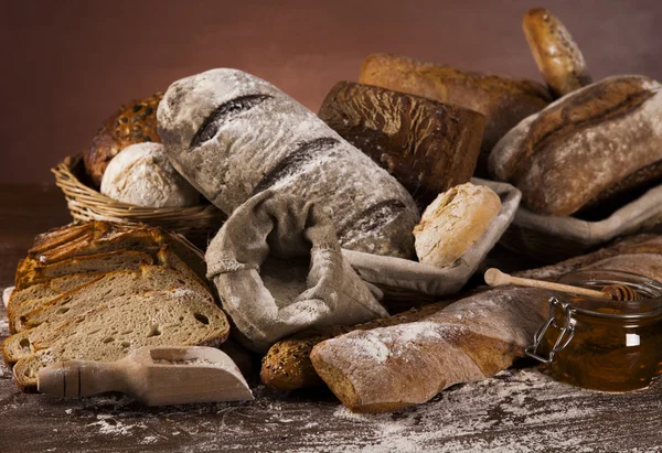 Freshly baked bread and jar of honey — Stock Photo, Image