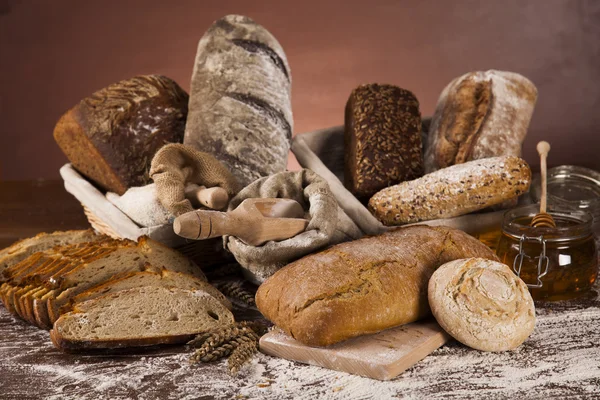 Freshly baked bread and jar of honey — Stock Photo, Image