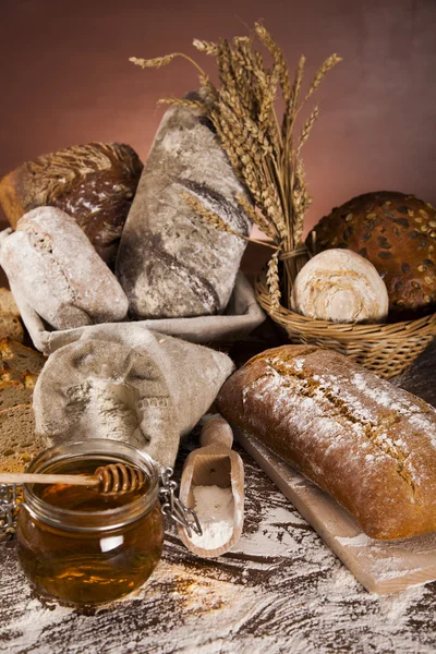 Freshly baked bread and jar of honey — Stock Photo, Image