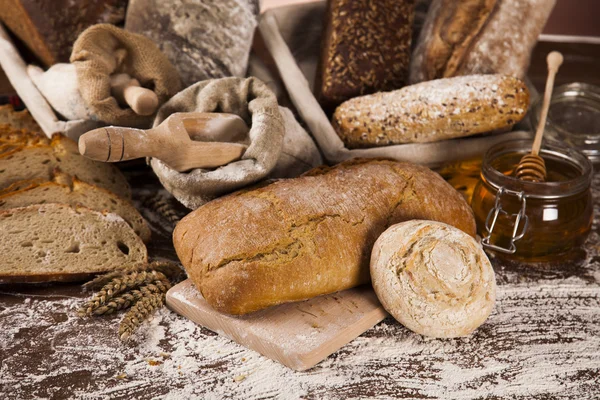 Freshly baked bread and jar of honey — Stock Photo, Image