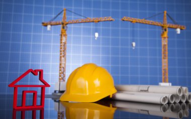 Vinç ve sarı bir kask ile inşaat planı