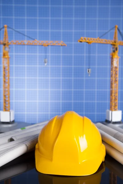 Guindaste, capacete de segurança, plantas e canteiro de obras — Fotografia de Stock