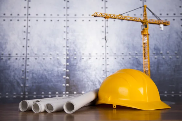 Construction plan with a crane and yellow helmet — Stock Photo, Image