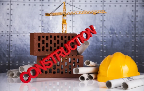 Construction plan with a crane and yellow helmet — Stock Photo, Image