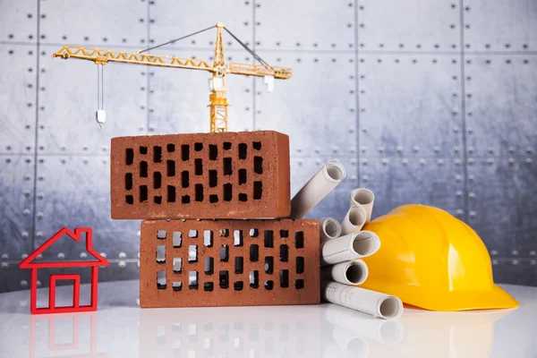 Construction plan with a crane and yellow helmet — Stock Photo, Image