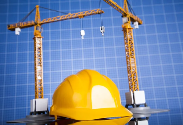 Construction plan with a crane and yellow helmet — Stock Photo, Image