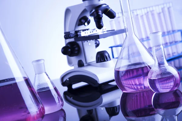 Microscope and glassware in laboratory — Stock Photo, Image