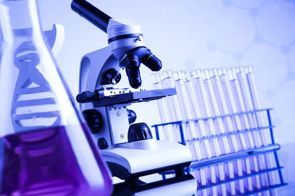 Microscope and glassware in laboratory — Stock Photo, Image