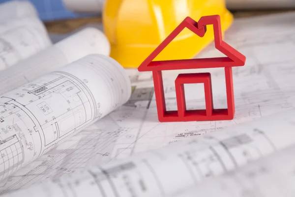 Capacete amarelo, desenhos de projeto e modelo de casa — Fotografia de Stock