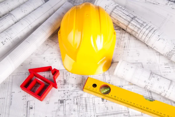 Capacete amarelo, desenhos de projeto e modelo de casa — Fotografia de Stock