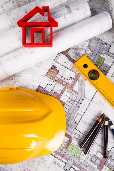 Желтый шлем, чертежи проекта и модель дома — стоковое фото