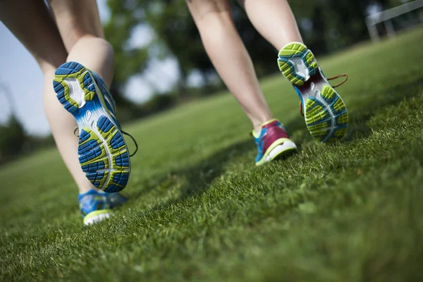 Kobiet jogging na zielonej trawie — Zdjęcie stockowe