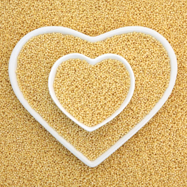 Millet Grain in heart shaped bowls — Stock Photo, Image