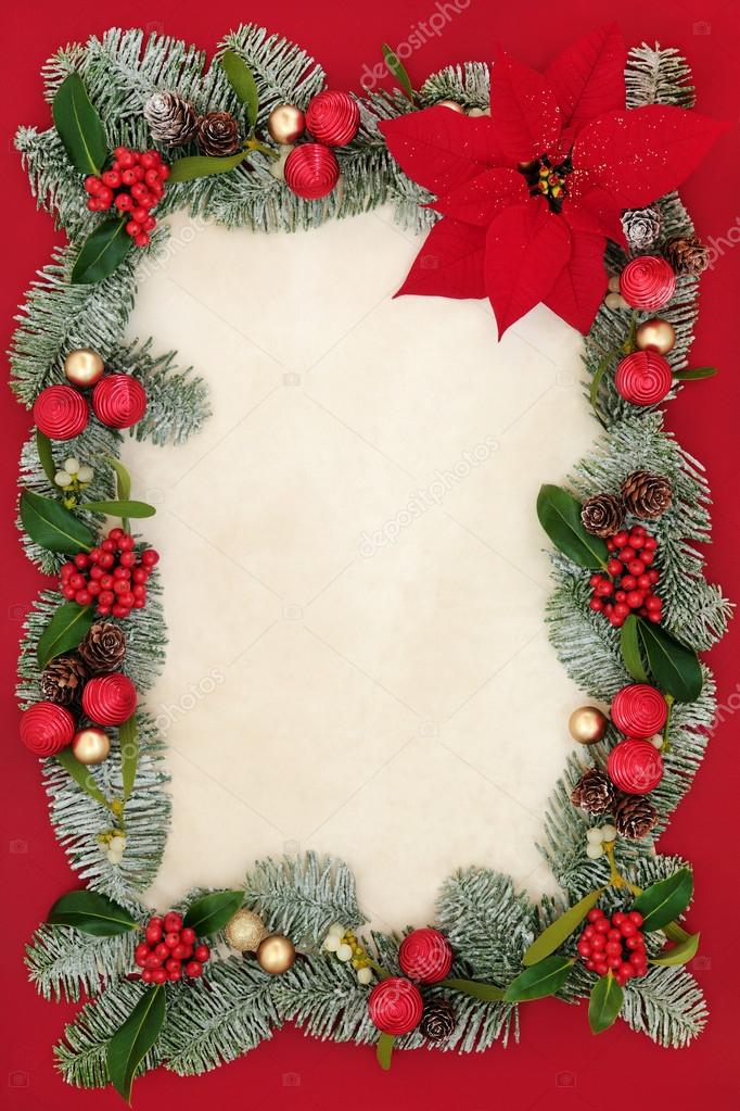 Christmas background border with poinsettia flower on parchment paper with  red and gold bauble decorations, holly, mistletoe, ivy, fir and pine cones  on oak Stock Photo