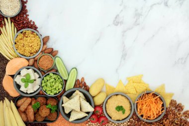 Sebzeler, baklagiller, tofu eti yerine geçen ürünler, tahıllar, çerezler ve sebzeler ile vejetaryen diyeti için sağlıklı yaşam tarzı yiyecekler. Yüksek protein, omega 3, antioksidan, lif, vitamin ve mineraller. Düz mermer üzerinde yatıyordu..