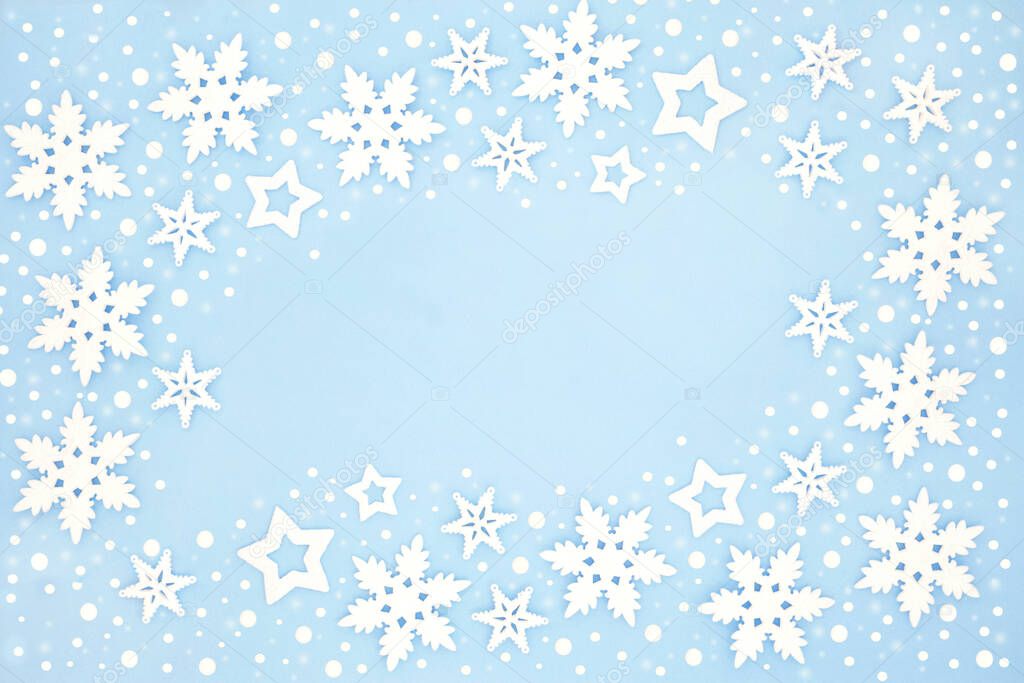 Winter and Christmas snowflake & star background border on pastel blue. Abstract xmas & New Year theme for the holiday season. Flat lay, top view, copy space.