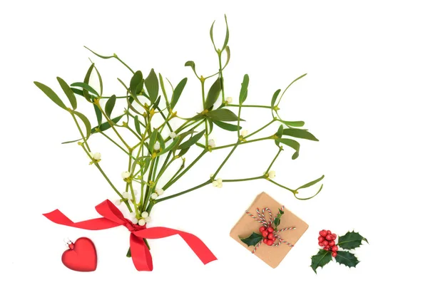 圣诞浪漫概念与寄生 红心易碎 冬季冬青浆果和礼品盒与生态友好的褐色包装纸白色背景 顶视图 复制空间 — 图库照片