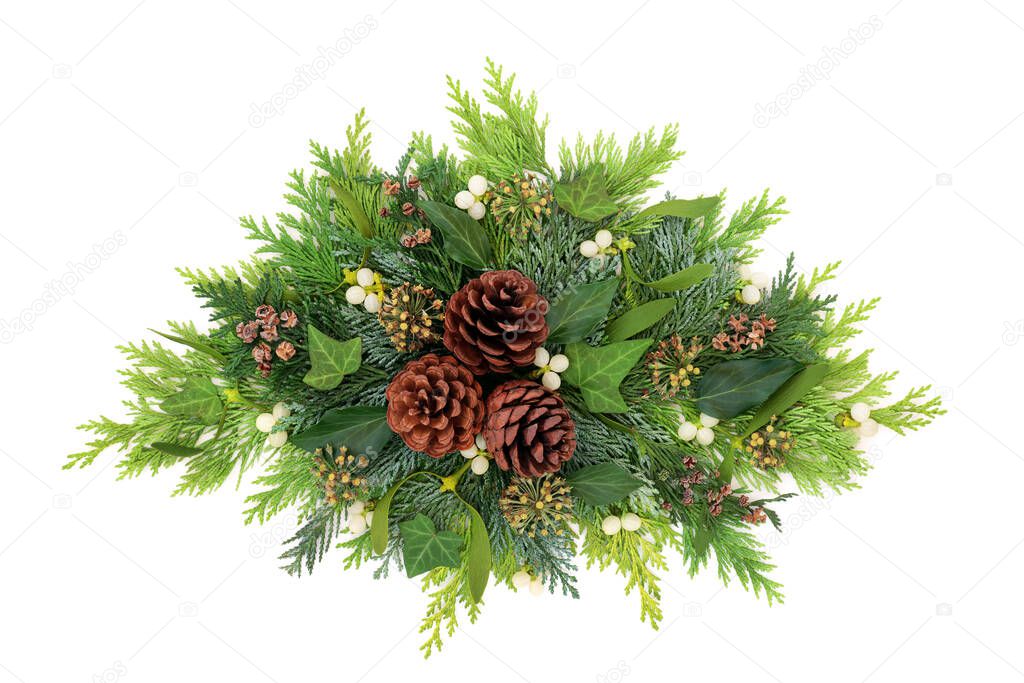 Winter & Christmas greenery floral decorative arrangement with cedar cypress fir leaves, mistletoe, pine cones & ivy on white background. Festive composition for xmas & New Year.