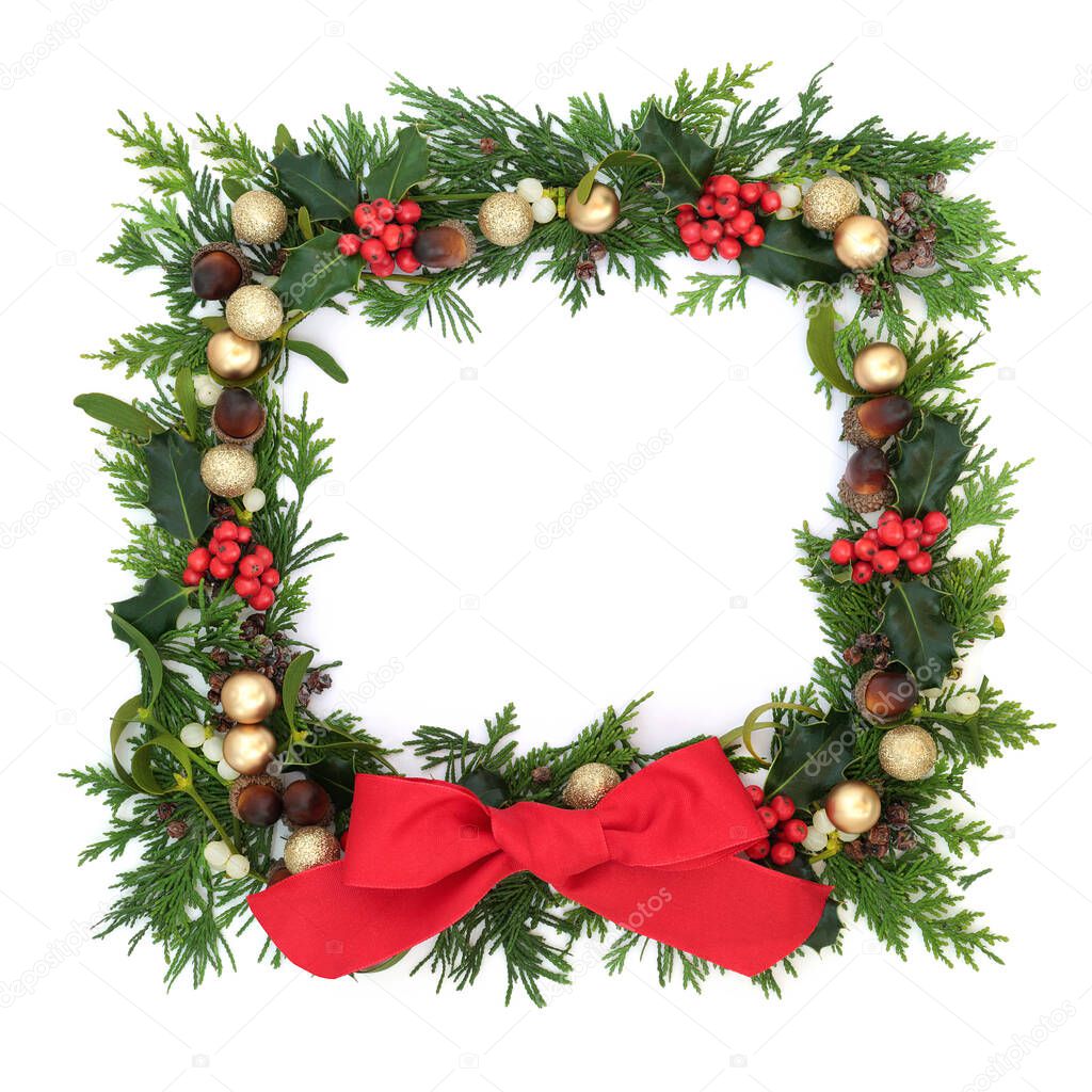 Christmas border decoration on white background with gold baubles & winter greenery of holly, ivy, mistletoe, juniper fir & cedar. Festive  element for the holiday season. Flat lay, top view, copy space.