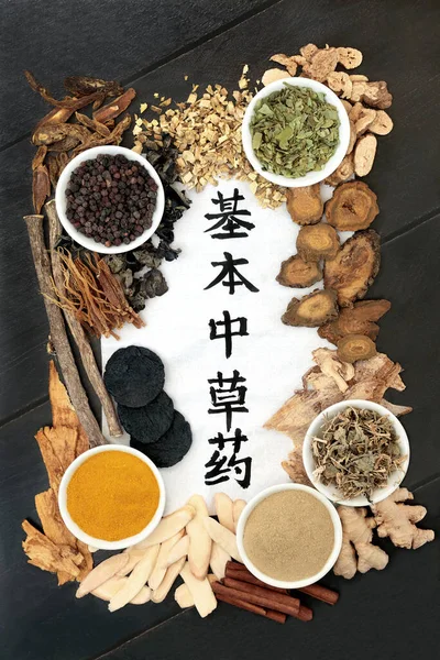 Chinese fundamental herb selection most frequently used in herbal medicine with calligraphy script on rice paper on black wood background. Top view. Translation reads as chinese fundamental herbs.