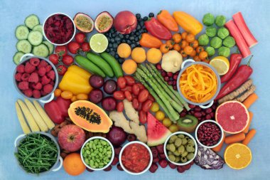 Serbest radikalleri meyve, yüksek lifli sebze, antosiyanin, likopene, protein, vitamin, mineral ve karotenoid ile nötralize eden antioksidan sağlıklı gıdalar. Sağlıklı gıda konsepti. Benekli mavi.