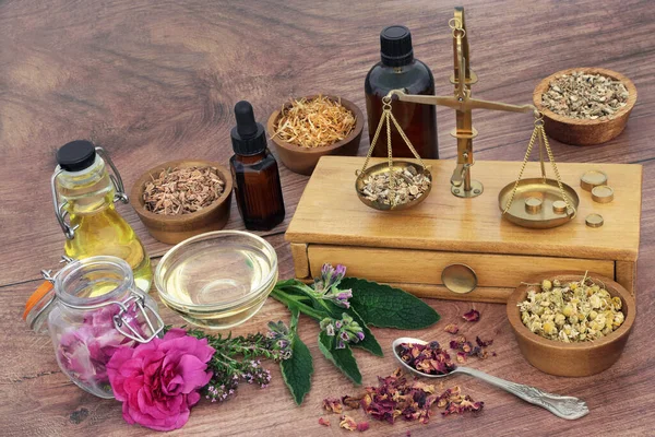 Naturopathic skincare healing herbs and flowers to treat eczema, psoriasis and acne with old brass scales for preparation of essential oil  treatments. Natural health care concept. On rustic wood.