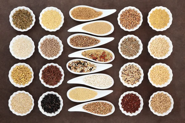Зерно и зерновые продукты питания в фарфоровых мисках — стоковое фото