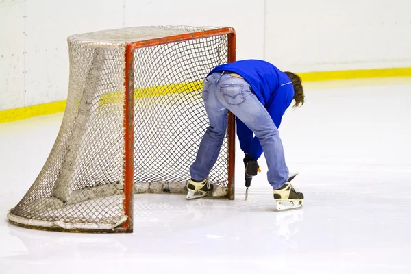 Fabricante de herramientas de trabajo cerca de la red de hockey sobre hielo —  Fotos de Stock