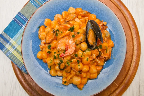 Blauwe schotel met gnocchi, zeevruchten en tomaten saus — Stockfoto