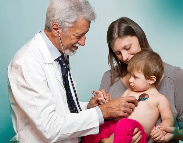 Mężczyzna lekarz badający pacjenta z dzieckiem — Zdjęcie stockowe