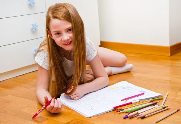 Menina desenha enquanto mentiras no chão . — Fotografia de Stock