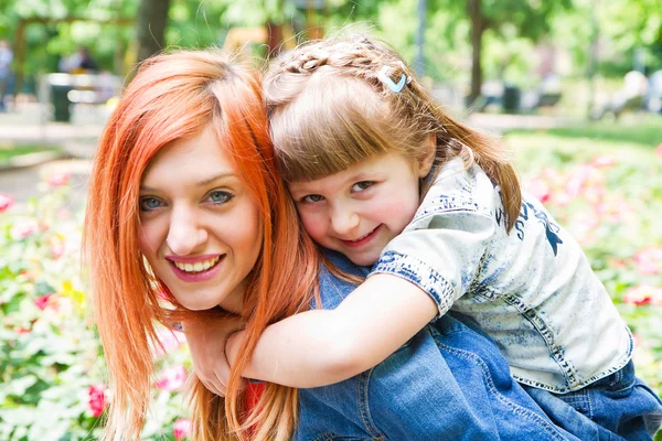 Mother and daughter hugging in love playing in the park — Stock Photo, Image