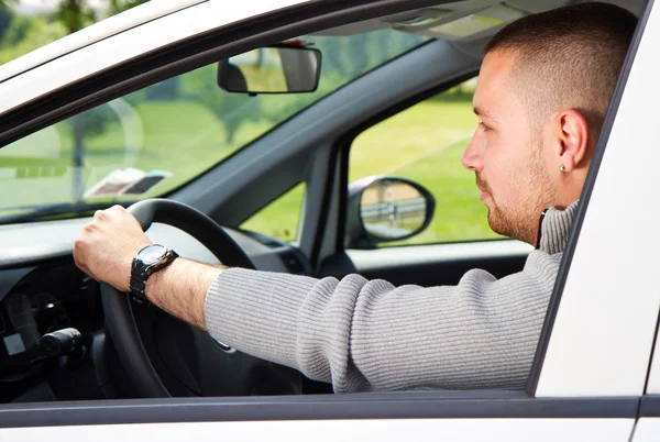 Een jonge man rijdt in een auto — Stockfoto