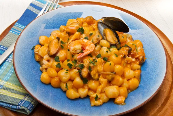 Blauwe schotel met gnocchi, zeevruchten en tomaten saus — Stockfoto