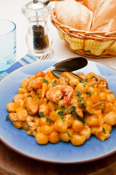 Plato azul con ñoquis, mariscos y salsa de tomates — Foto de Stock