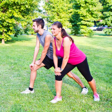 gülümseyen çift streching Park yapıyor