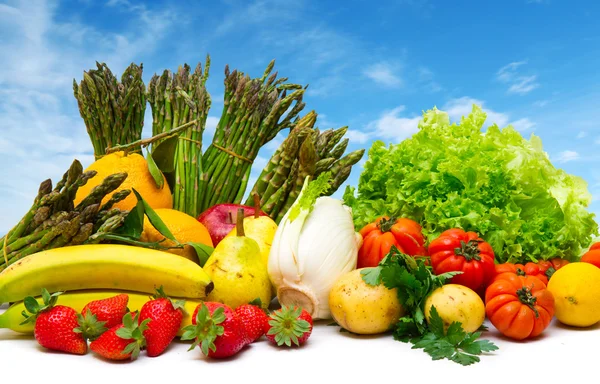Смешанные фрукты и овощи с голубым небом — стоковое фото