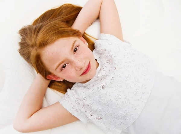 Young girl is lying on the bed. Quality mattress. — Stock Photo, Image