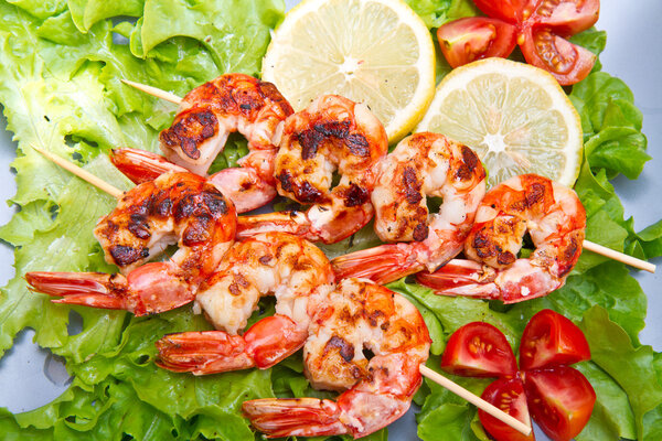 plate of grilled prawns with salad and cherry tomatoes