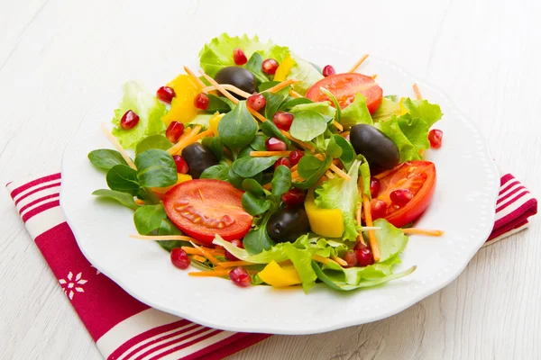 Salada mista com tomates em placa branca na mesa de madeira — Fotografia de Stock