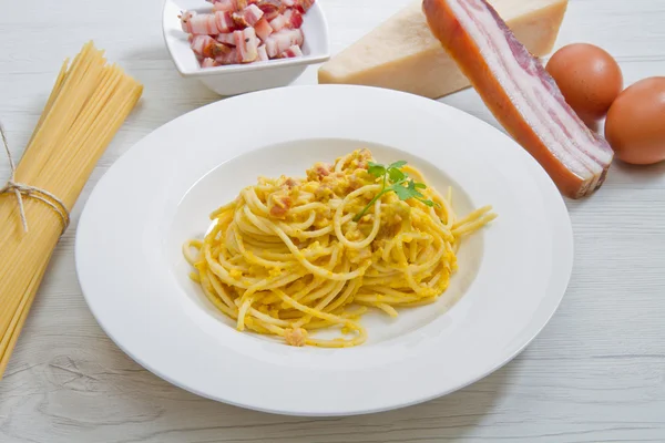 Plato con espaguetis de carbonara e ingredientes — Foto de Stock