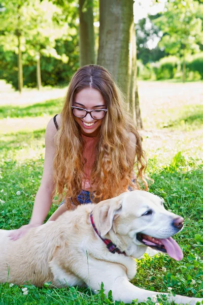 Девушка играет со своей собакой-лабрадором в парке — стоковое фото