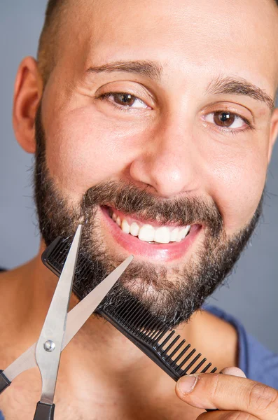 Portrait of a man grooming his beard with scissors — Stock Photo, Image