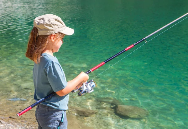 Young girl fishing in a lake in the mountains — Stock Photo, Image