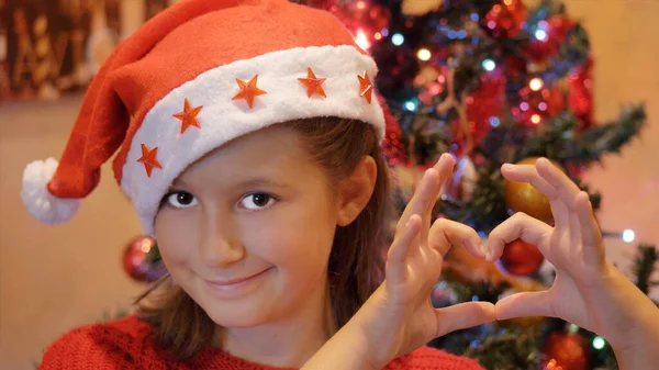 Young Girl Sants Claus Hat Doing Heart Shape Hands Christmas — Stock Photo, Image